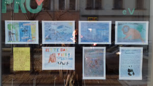 Selbst gestaltete Plakte hängen im Schaufenster des Staddteilbüros
